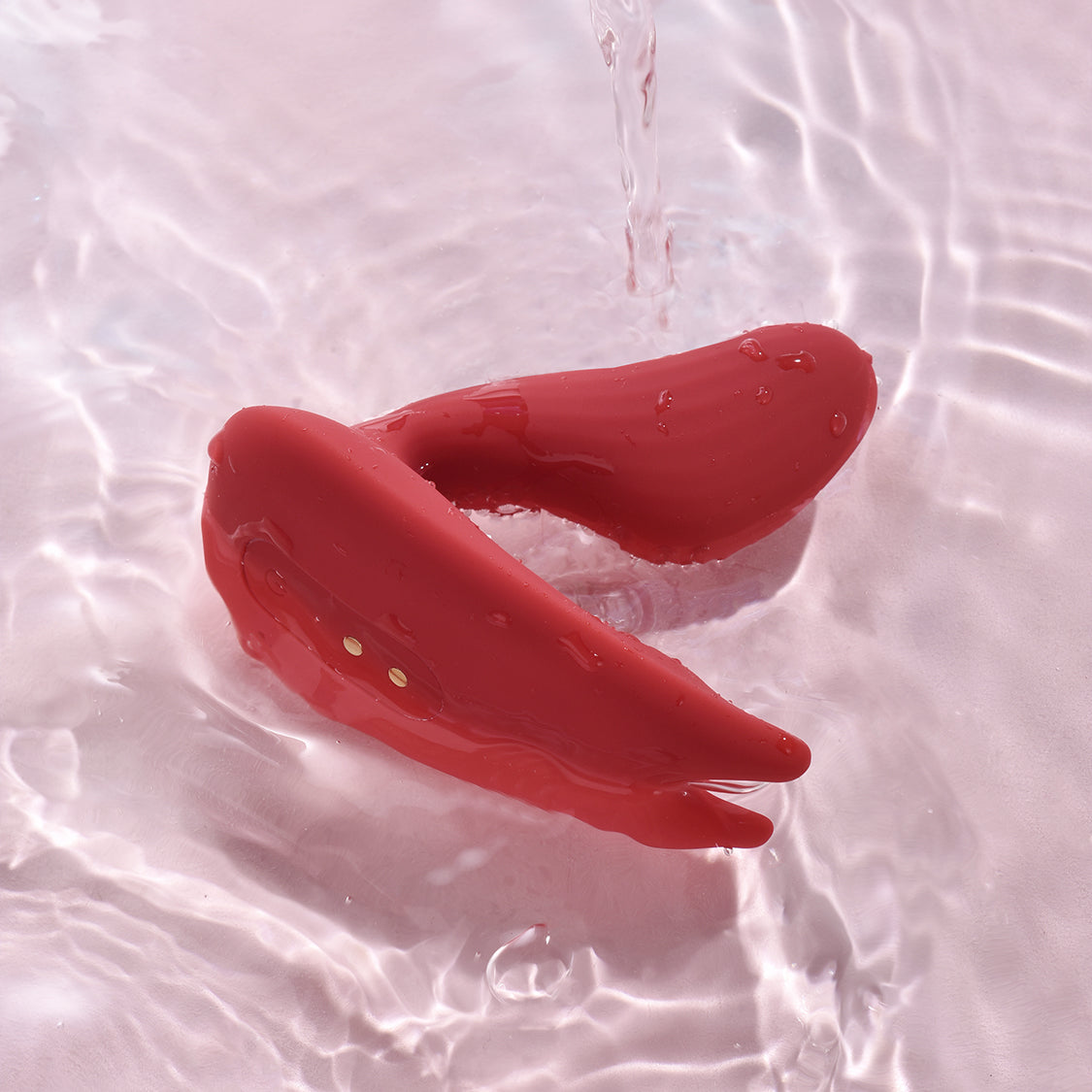 Magic Umi red wearable vibrator on soft pink fabric
