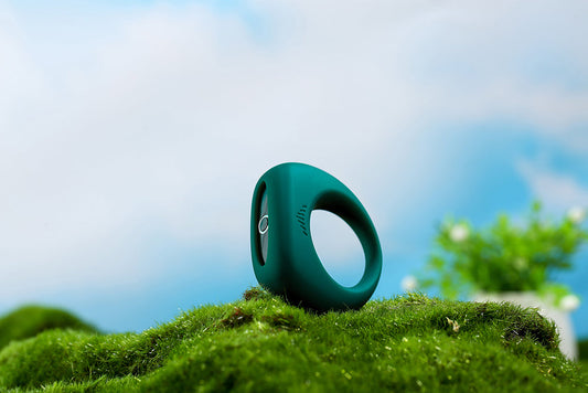 Dark green smart cock ring standing on moss.